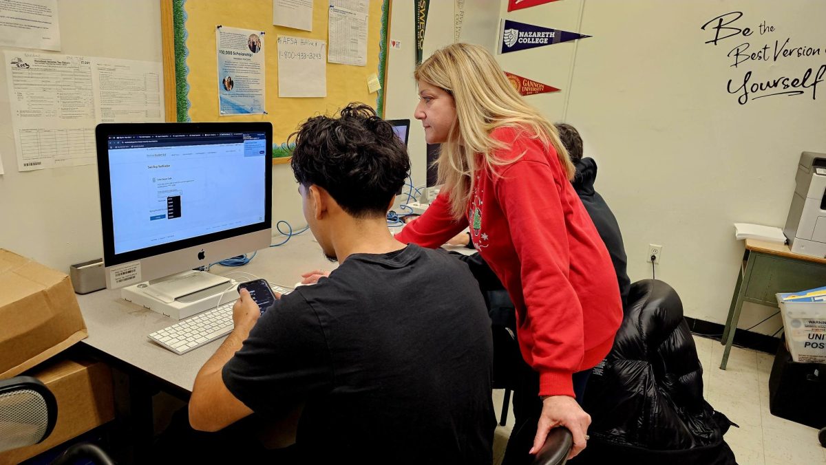 College counselor Ms. Mazzola helps a student filling out the FAFSA. Students often utilize the college office throughout the school day in order to access important services related to applying to college or vocational programs. 