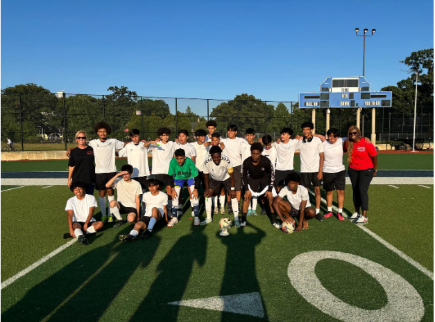 The boy's soccer team standing triumphantly after their last game of the season. 