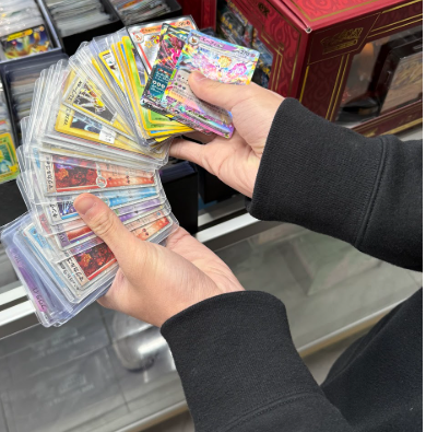 Joseph Chang, a senior at John Dewey, is looking at cards to buy. These cards can be seen in sleeved and top loaders ensuring their protection.