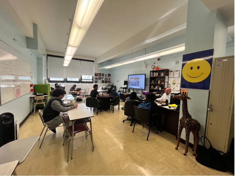 A look inside the Intervention Room, where Mr. Satira speaks with two students at his desk while others engage in a variety of activities- from chess, to working on assignments for their classes. 