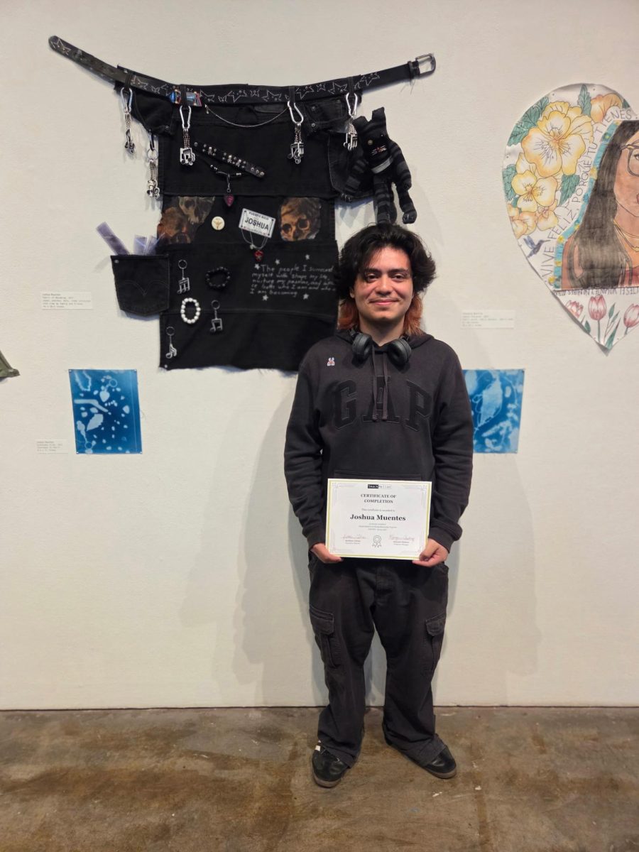 Senior Joshua Muentes posing with the art he created as part of the Art Mentorship program through SmackMellon that he and three other Dewey students (Diana Martinez-Lozada, Sophia Nikishova, and Eric Huang) were involved with.
