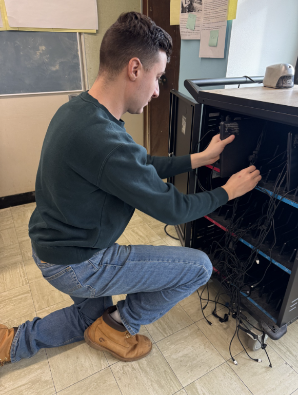 Journalism Teacher Mr. Inoa organizing the Chromebook Cart in his classroom. Many staff are in favor of student owned devices because managing the Chromebook cart can be a time-consuming part of each teacher's day.